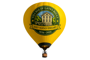 a yello hot air balloon withe a green circular logo with the Village of Gates Mills arching around a sawmill