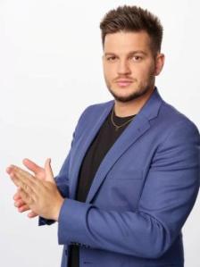 man wearing a blue suit jacket with a black t-shire
